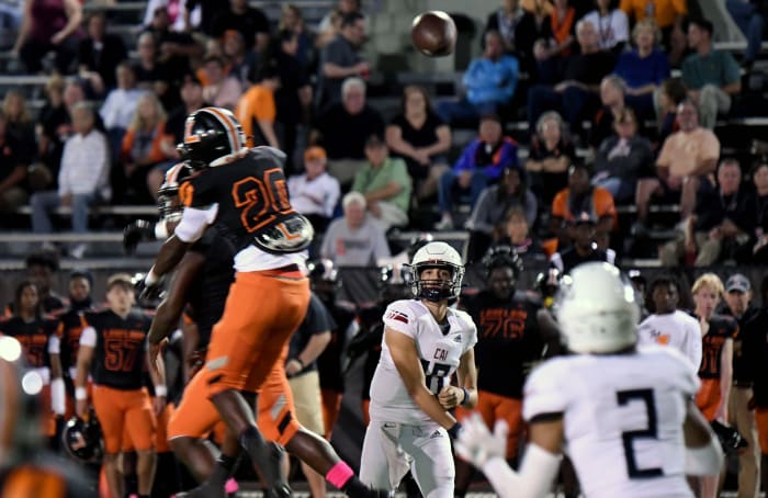 Clearwater Academy International quarterback Joaquin Kavouklis fires a pass through the Lakeland defensive pressure on Friday at Bryant Stadium in Lakeland,